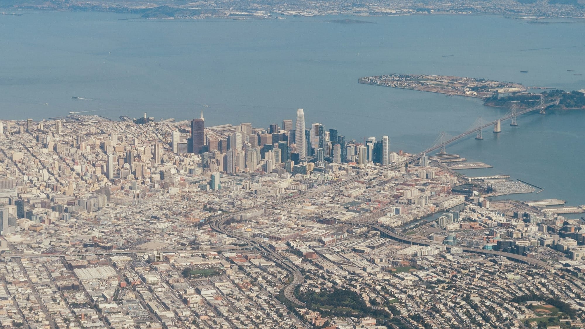 aerial view of city buildings near body of water during daytime